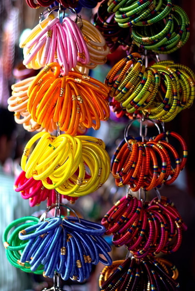 Stacks of coloured bangles hanging at a market stall — upscaled by GoStudio Advanced