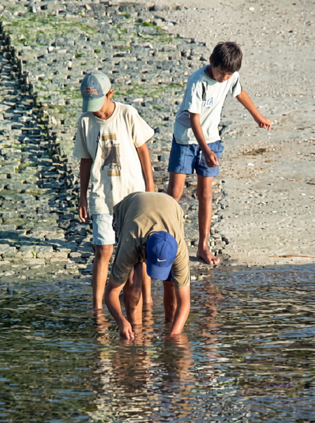 Three boys paddling in shallow water at the foot of a stone slipway — upscaled by GoStudio Advanced