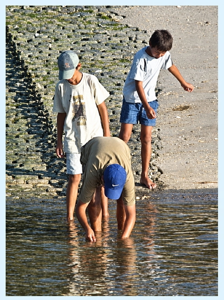 Three boys paddling in shallow water at the foot of a stone slipway — upscaled by GPT Image 2.5