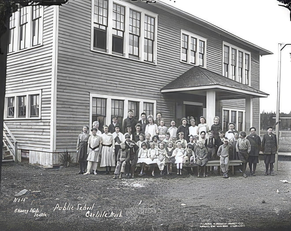 Black-and-white school photograph of pupils lined up in front of a two-storey clapboard school — upscaled by GoStudio Pro
