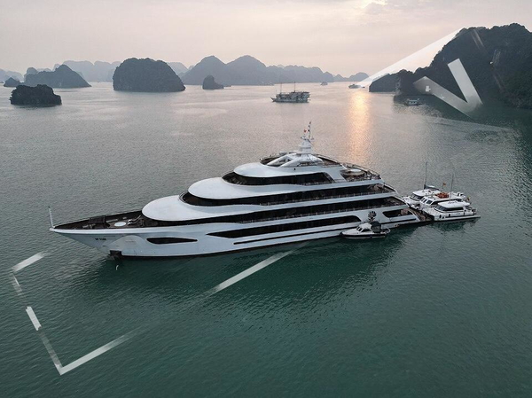 Aerial view of a white superyacht moored among limestone karsts at dusk — watermark removed by GoStudio Lite