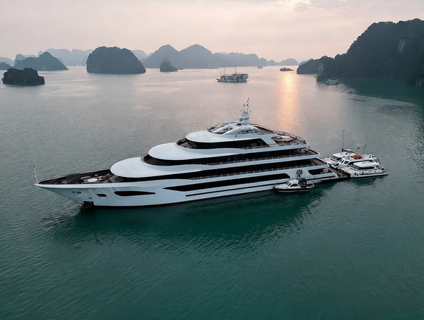 Aerial view of a white superyacht moored among limestone karsts at dusk — watermark removed by GoStudio Pro