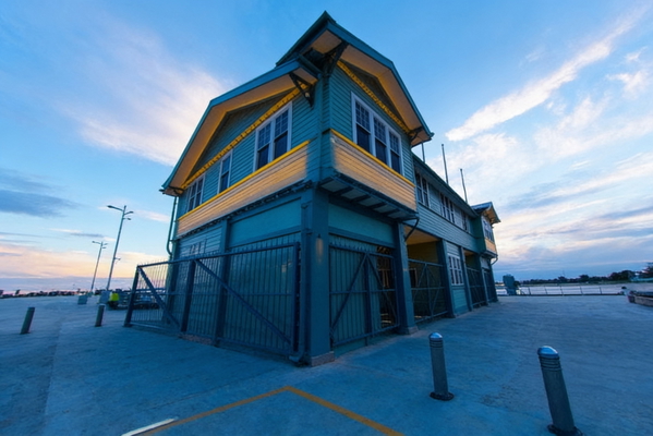 Blue and yellow timber pier building under a wide evening sky — watermark removed by GoStudio Advanced