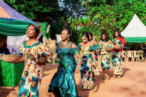 Women in patterned dresses dancing at an outdoor celebration — watermark removed by GoStudio Advanced