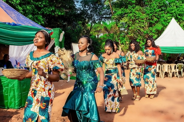 Women in patterned dresses dancing at an outdoor celebration — watermark removed by GoStudio Pro