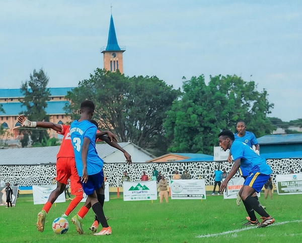 Two football players challenging for the ball in front of a stand and a church spire — watermark removed by GoStudio Pro