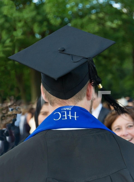 Graduate seen from behind in a mortarboard and blue stole, crowd beyond — watermark removed by GoStudio Lite