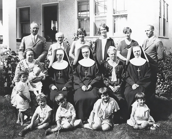 Black-and-white group photo of nuns, adults and children outside a building — watermark removed by GoStudio Pro