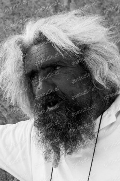 Black-and-white portrait of a man with wild white hair and a long beard