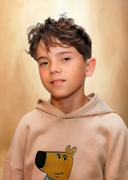 Studio portrait of a boy in a beige hoodie with a cartoon dog on it — watermark removed by GoStudio Pro