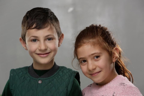 Studio portrait of a boy and a girl, heads together — watermark removed by GoStudio Lite