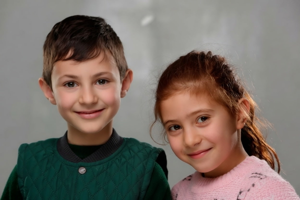 Studio portrait of a boy and a girl, heads together — watermark removed by GoStudio Pro