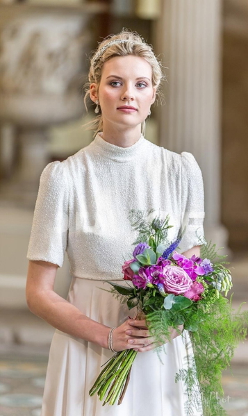 Bride in a white high-necked dress holding a bouquet of roses and lavender — watermark removed by GoStudio Lite