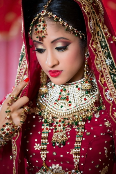Bride in a red and gold dupatta with heavy gold jewellery — watermark removed by GoStudio Pro