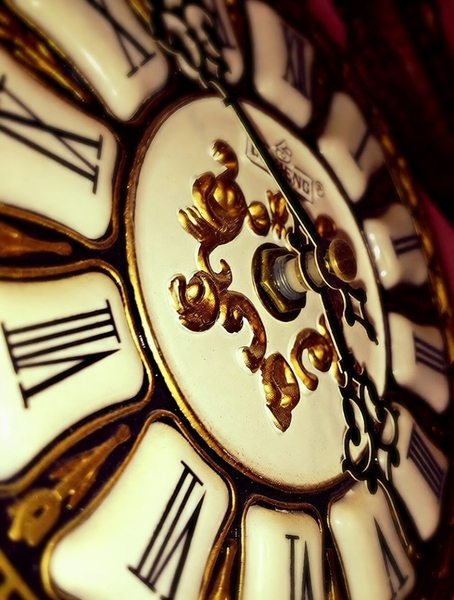 Close-up of an ornate clock face with Roman numerals and gold scrollwork — watermark removed by GoStudio Pro