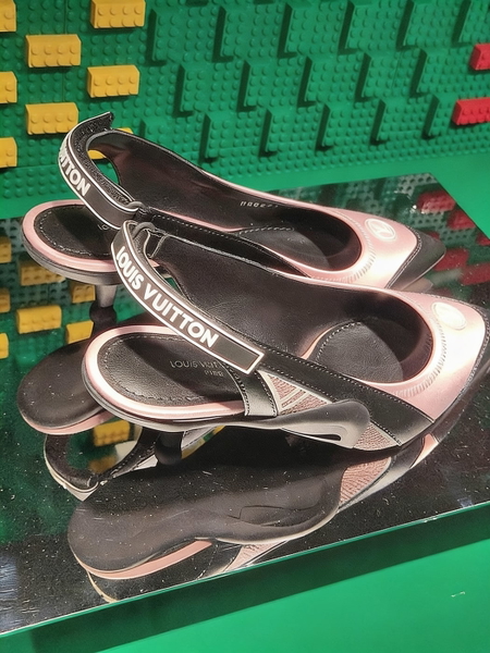 Pair of branded slingback shoes on a mirrored stand against green bricks — watermark removed by GoStudio Advanced