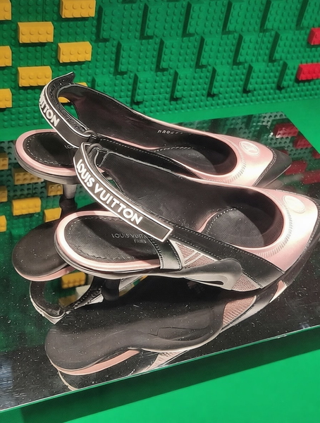 Pair of branded slingback shoes on a mirrored stand against green bricks — watermark removed by GoStudio Pro