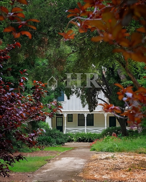 House glimpsed through green and red foliage at the end of a path — watermark removed by GoStudio Pro