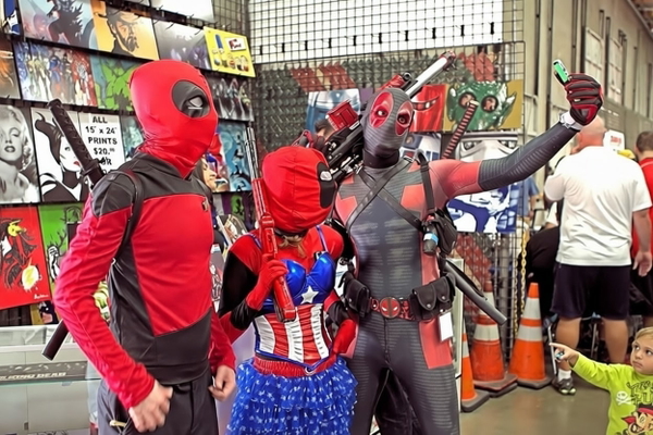 People in superhero costumes at a comic convention stall — watermark removed by GoStudio Pro