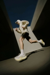 Man in a white hoodie and black shorts running on a skateboard — sample image to enlarge
