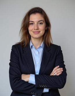 A woman in a business suit, smiling, standing against a white background. Individual professional headshot for a team group photo. A woman in a business suit, smiling, standing against a white background. Individual professional headshot for a team group photo.