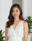 A smiling woman in a white dress beside a plant, a sample portrait to try in the AI makeup studio.