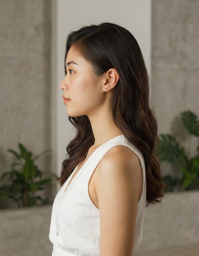 A woman in a white dress standing in front of a wall with plants, re-rendered from a left-side profile by AI. A woman in a white dress standing in front of a wall with plants, re-rendered from a left-side profile by AI.