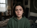 Portrait of a woman with freckles in a green hoodie, before eye detail enhancement in the portrait enhancer