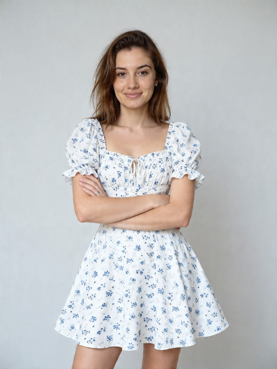 A woman smiling, wearing a white dress with blue flowers, after AI virtual try-on. A woman smiling, wearing a white dress with blue flowers, after AI virtual try-on.