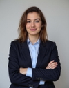 A woman in a business suit, arms crossed, smiling, standing against a white background. Photo uploaded before AI virtual try-on.