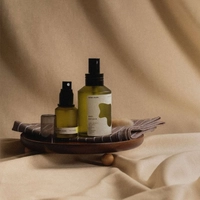 Sample product photo of two amber skincare bottles on a wooden tray to try in the AI image replacer