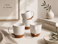 Four white speckled mugs on a table