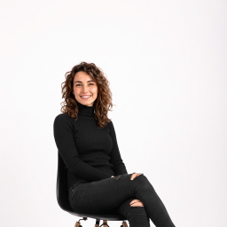 A woman in a black turtleneck seated with her legs crossed, a sample photo for the AI pose changer.