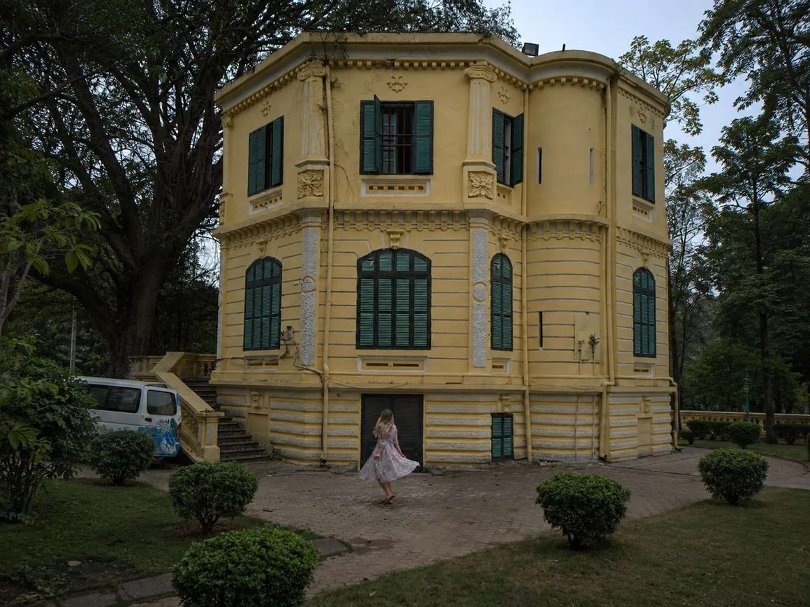 The same building with yellow walls, green shutters and a clear sky — after color correction The same building with yellow walls, green shutters and a clear sky — after color correction