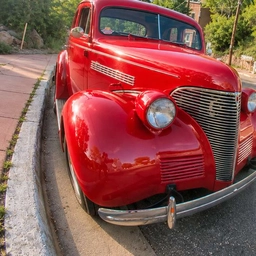 Fisheye photo of a red vintage car with a curved curb, a sample photo for lens distortion correction