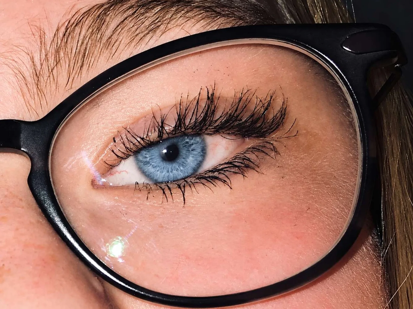 An eye behind black glasses after the eye color changer, the iris a lighter blue-gray and the frames unchanged An eye behind black glasses after the eye color changer, the iris a lighter blue-gray and the frames unchanged