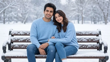 A couple on a snowy park bench, both with dark hair and brown eyes.