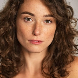 A woman with curly brown hair and freckles - a sample photo to try in the hair color changer.
