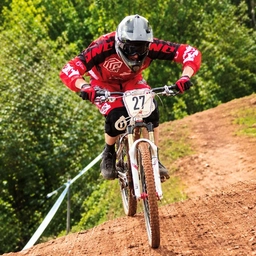 A mountain biker riding down a dirt track toward the camera, a sample photo for a zoom burst.
